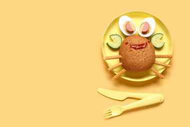 Sarı arka planda yengeç şeklinde komik çocuk kahvaltısı tabağı.