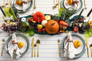 Şükran Günü için balkabakları, mumlar ve altın çatal bıçaklarla şenlik masası.