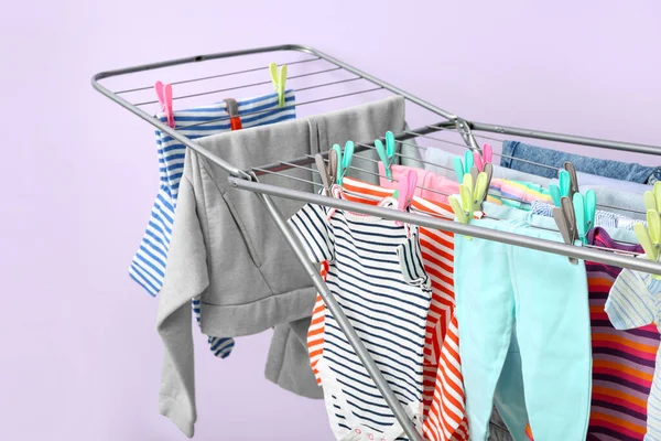 Leylak duvarının yanındaki kurutucuda asılı temiz bebek kıyafetleri.