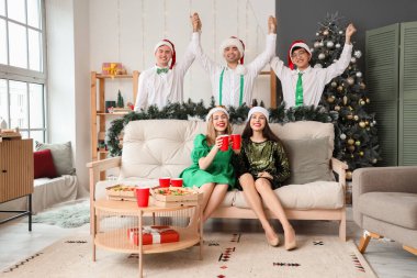 Bir grup genç arkadaş Noel 'i evde kutluyor.