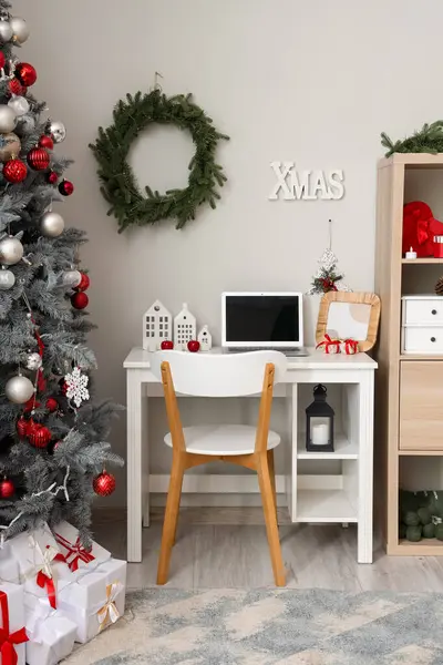 Interior of office with workplace and Christmas tree