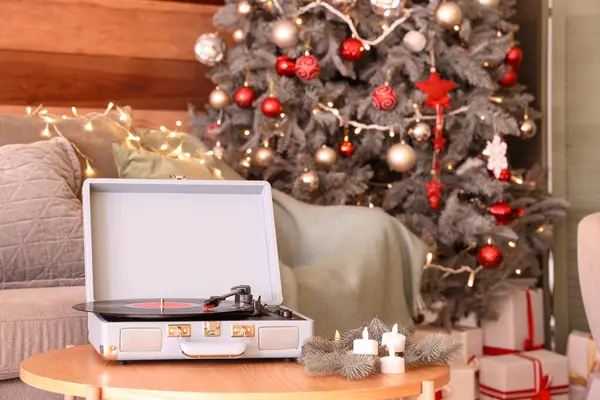 Record player on table in living room decorated for Christmas