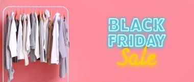 Pembe duvarın yanında şık kıyafetler var. Kara Cuma İndirimi