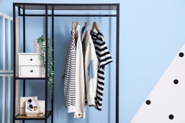 Soyunma odasında giysi ve aksesuarlı raf ünitesi.