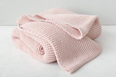 Işık duvarının yanındaki masada yeni örülmüş bir battaniye.