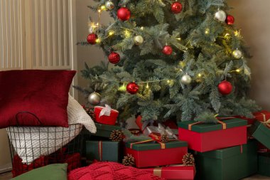 Oturma odasında hediyelerle parlayan Noel ağacı