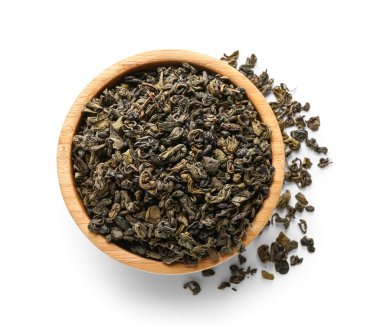 Beyaz arka planda kuru yeşil çay yapraklı ahşap kase.