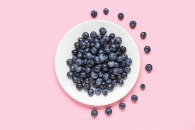 Pembe arka planda taze yaban mersini tabağı