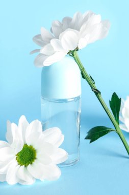 Renkli papatya çiçekli bir şişe deodorant.