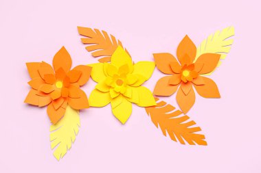 Mor arka planda yaprakları olan renkli origami çiçekleri