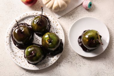 Beyaz arka planda Cadılar Bayramı için lezzetli karamelli elma tabakları