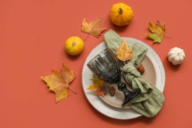 Kırmızı zemin üzerinde balkabakları ve yaprakları ile sonbahar masa ayarları
