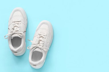 Mavi arka planda şık beyaz spor ayakkabılar