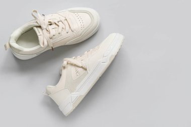 Gri arkaplanda şık beyaz spor ayakkabılar