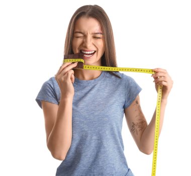 Çikolatalı genç bir kadın ve beyaz arka planda mezura.