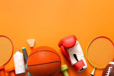Turuncu arka planda farklı spor ekipmanları