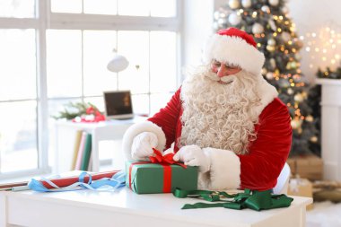 Noel Baba evde Noel hediyesi yapıyor.