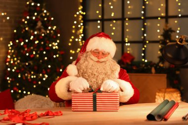 Noel Baba evde Noel hediyesi yapıyor.