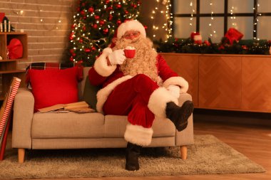 Noel Baba, Noel arifesinde evde lokumla sıcak çikolata içiyor.