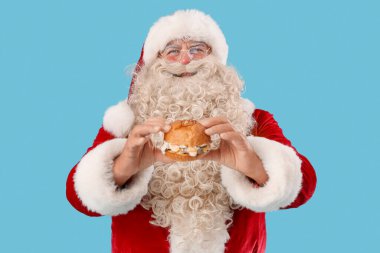 Mavi arka planda lezzetli burgerli Noel Baba
