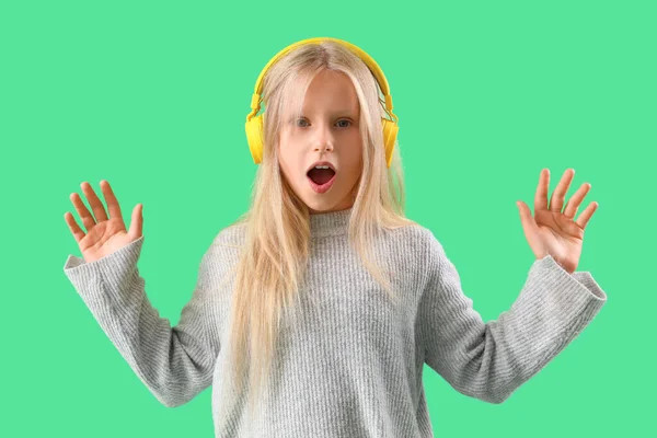 Petite Fille Choquée Dans Les Écouteurs Sur Fond Vert — Photo