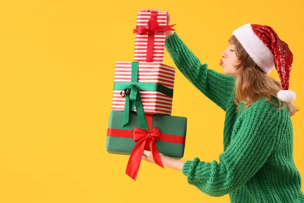 Young Woman Santa Hat Christmas Presents Blowing Kiss Yellow Background — Stock Photo, Image