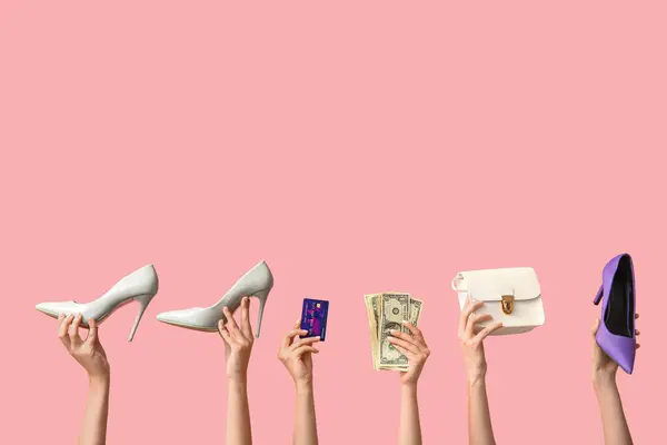 Female hands with shoes, money, purse and credit card on pink background. Black Friday sale