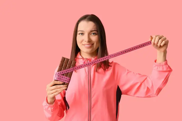 Krásná Mladá Žena Čokoládovou Tyčinkou Páskou Opatření Růžovém Pozadí — Stock fotografie