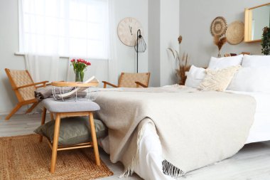 Şık bir yatak odası, rahat bir yatak odası ve yatağın yanında bir bank.