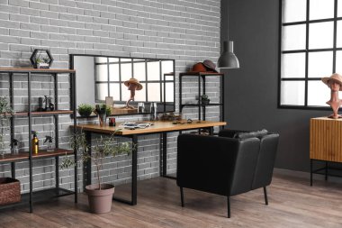 Rahat koltuğu, masası ve aynası olan bir güzellik salonu.