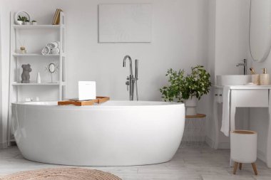 Banyonun içinde küvet, raf ünitesi ve tuvalet masası var.