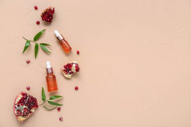 Gerekli yağ şişeleri, olgun nar ve renk arkaplanına bitki dalları ile bileşim