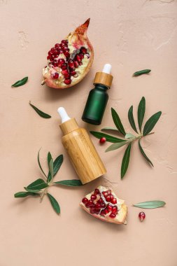 Renkli arka planda gerekli yağ, nar ve bitki dallarından oluşan şişelerle bileşim