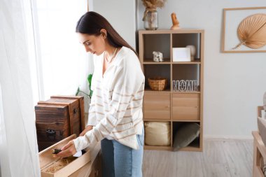 Genç bayan eve bir şişe şarap götürüyor.