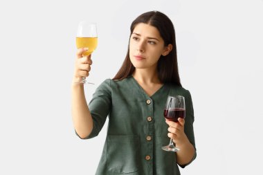 Hafif arka planda şarap kadehleri olan genç bir kadın.