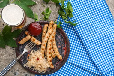 Lezzetli Bavyera sosisi, sos, lahana turşusu ve gri arka planda bir bardak bira. Ekim Festivali Kutlaması