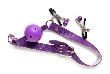 Mor ağız tıkacı ve beyaz arka planda seks dükkanından meme ucu kıskaçları.