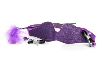 Beyaz arka planda seks dükkanından tüy çubuğu ve meme ucu kıskaçlı mor maske.