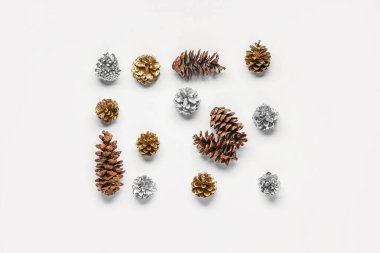 Beyaz arka planda çam kozalakları olan Noel kompozisyonu