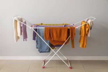 Temiz kış giysileri ışık duvarının yanındaki kurutucuda asılı.