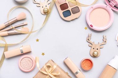Makyaj ürünlerinden yapılmış çerçeve ve beyaz arka planda Noel dekoru