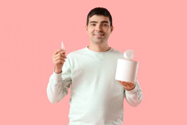 Genizden damlalar ve pembe renkli mendil kutusu olan genç bir adam.