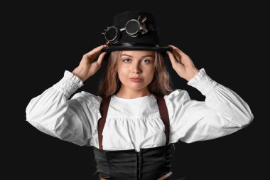 Siyah arka planda steampunk gözlükleri olan genç bir kadın.