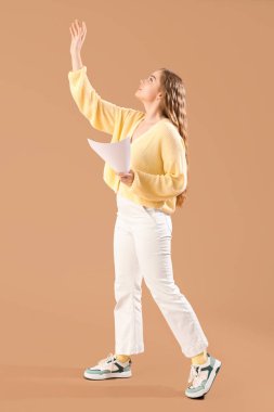 Bej arkaplanda film senaryosu olan güzel bir aktris.