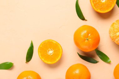 Bej arkaplanda tatlı mandalinalar ve yapraklar