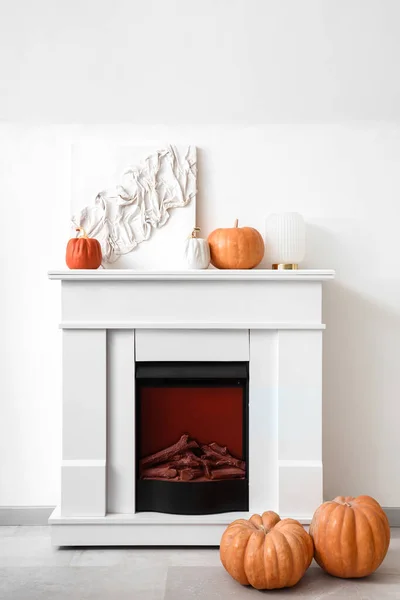 Electric fireplace with pumpkins and painting in room
