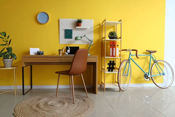Interior of home office with workplace and bicycle