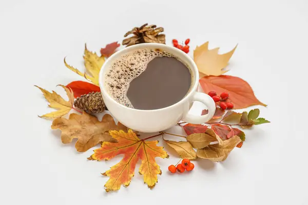 Cup of coffee with autumn leaves and natural forest decor on white background