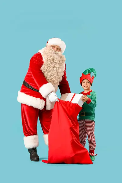 Santa Claus Roztomilý Malý Elf Taškou Plnou Vánočních Dárků Modrém — Stock fotografie