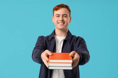 Genç adam elinde renkli arkaplan kitapları tutuyor.